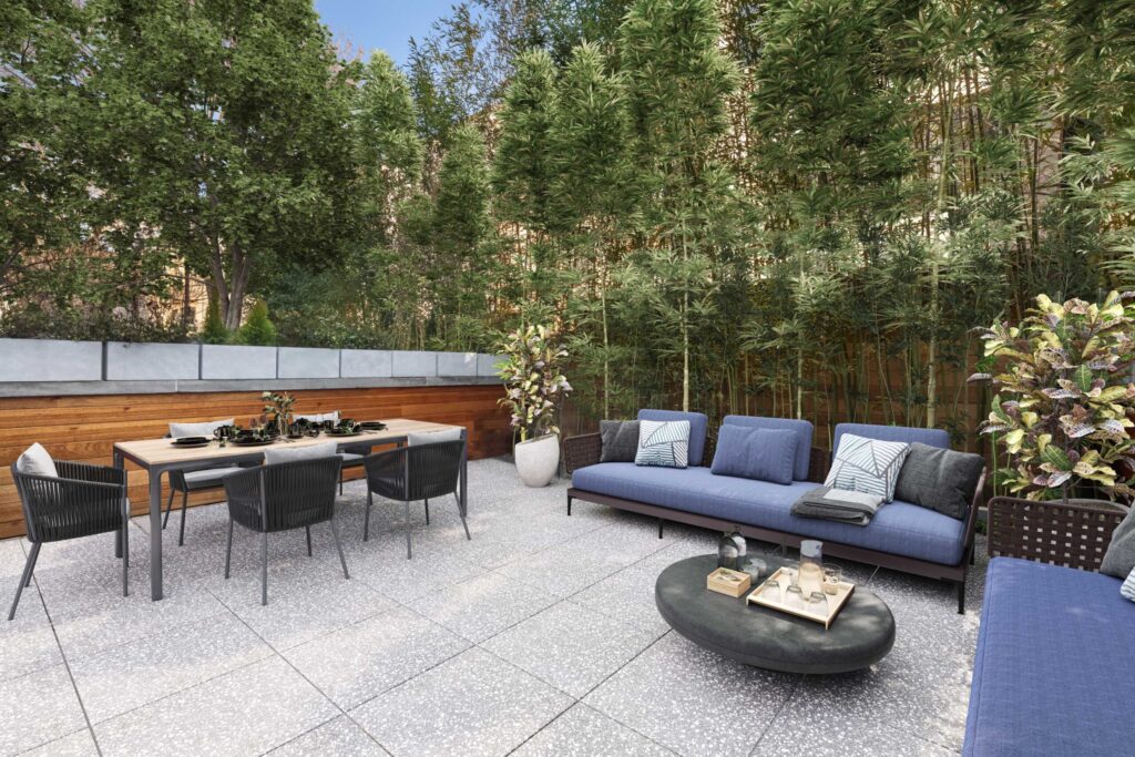Rendu extérieur d’une terrasse avec canapés bleus et table, entourée d’arbres