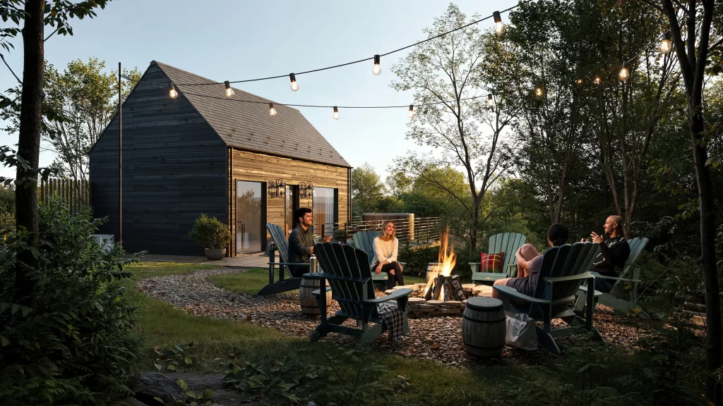 Extérieur d’un chalet en bois avec brasero de jardin et guirlandes lumineuses au crépuscule